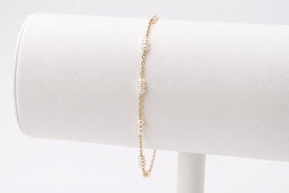 Pearl bracelet on a white mannequin bust with a plain background