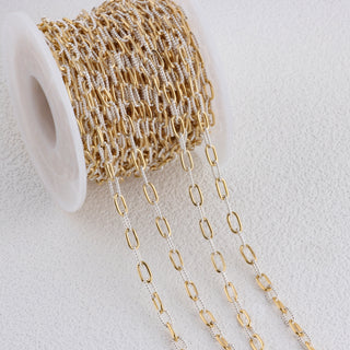 Mixed Gold and Silver chain spool on a light gray background