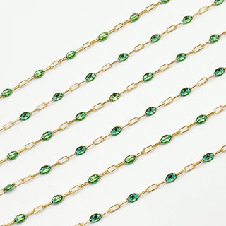 Gold chain with green gemstones on a white background