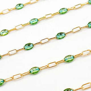 Gold chain with green leaf-like links on a white background